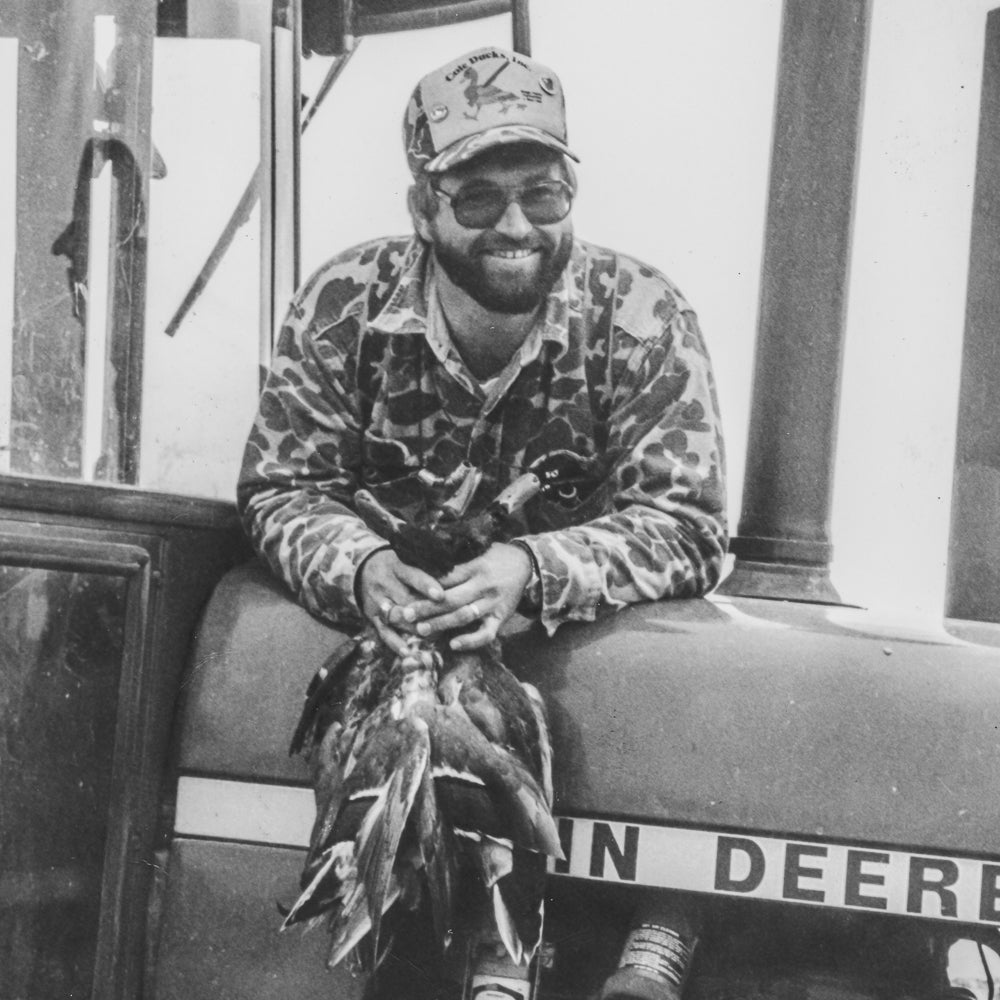 Vintage photo of Rick Hampton holding mallards after a succdesful hunt in the legendary Arkansas flooded green timber of Arkansas.
